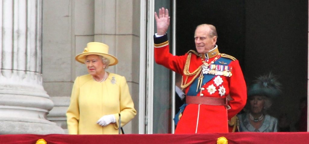 El duque de Edimburgo y la reina Isabel II saludando desde el balcón
