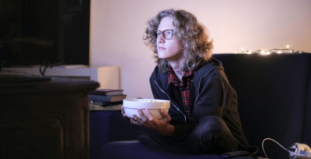 Mujer viendo la televisión con un cuenco de palomitas el 28 de marzo