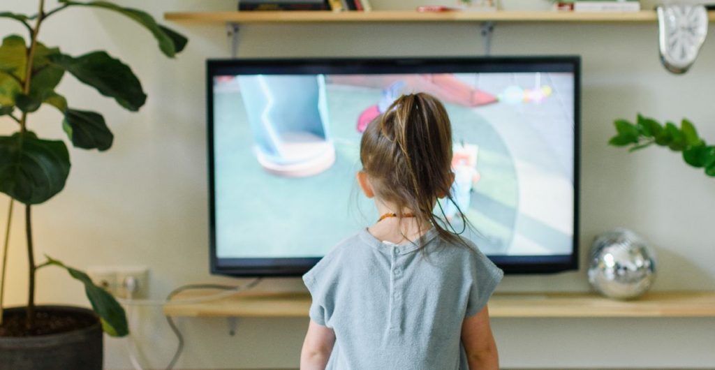 Niña sentada mira fijamente al televisión el 31 de marzo