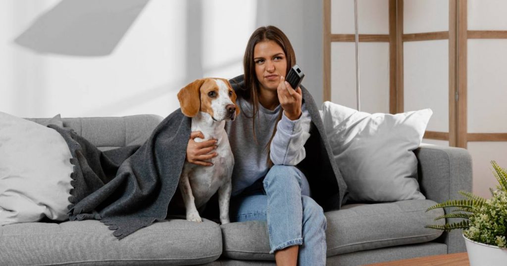 Chica joven junto a su perro ve la televisión el 2 de abril