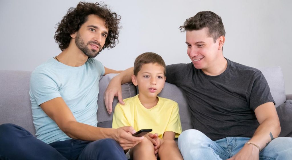 Dos hombres y un niño ven la televisión el 20 de abril