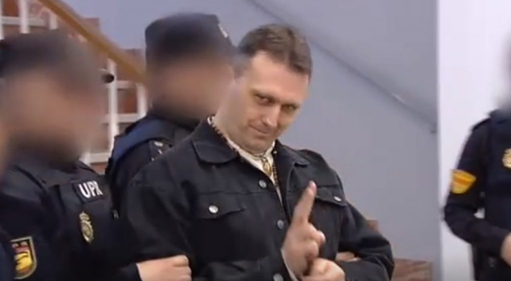 Norbert Feher entrando al juzgado escoltado y haciendo el símbolo de la victoria