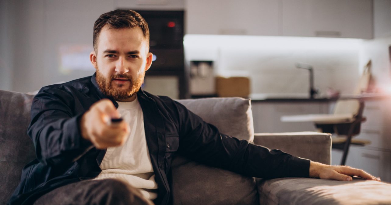Hombre apunta con el mando y ve la televisión el 8 de mayo