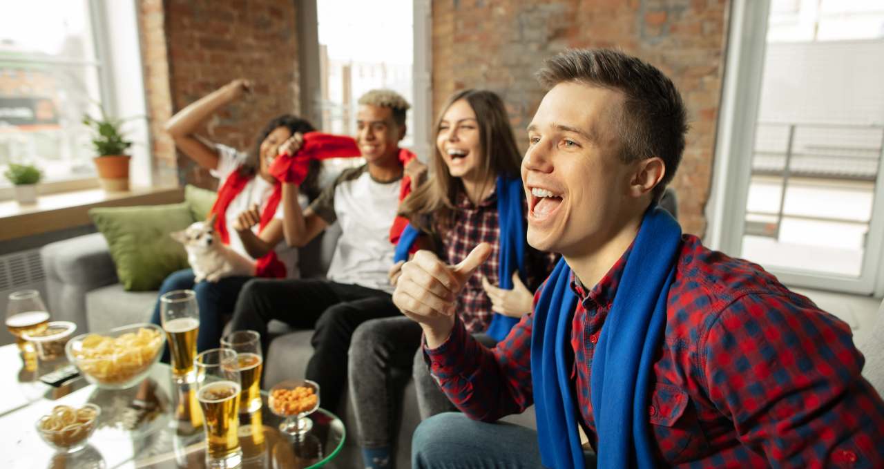 Grupo de amigos ve la televisión el 23 de junio