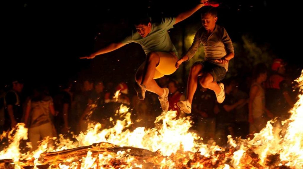 Dos hombres saltando una hoguera durante la noche de San Juan