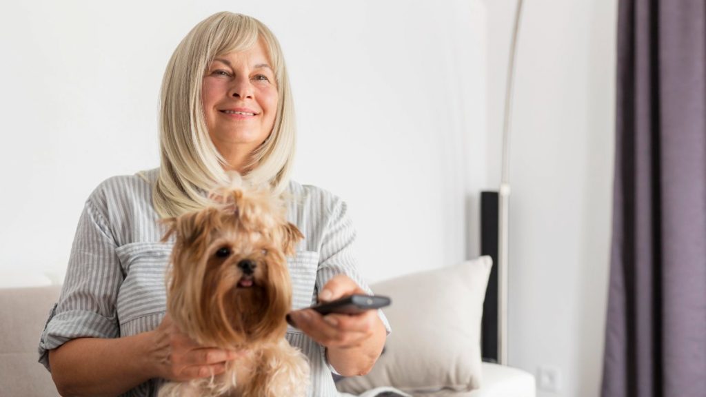 Mujer ve la televisión con su perro el 1 de julio