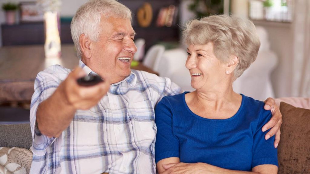 Pareja de ancianos ve la televisión la noche del 6 de agosto