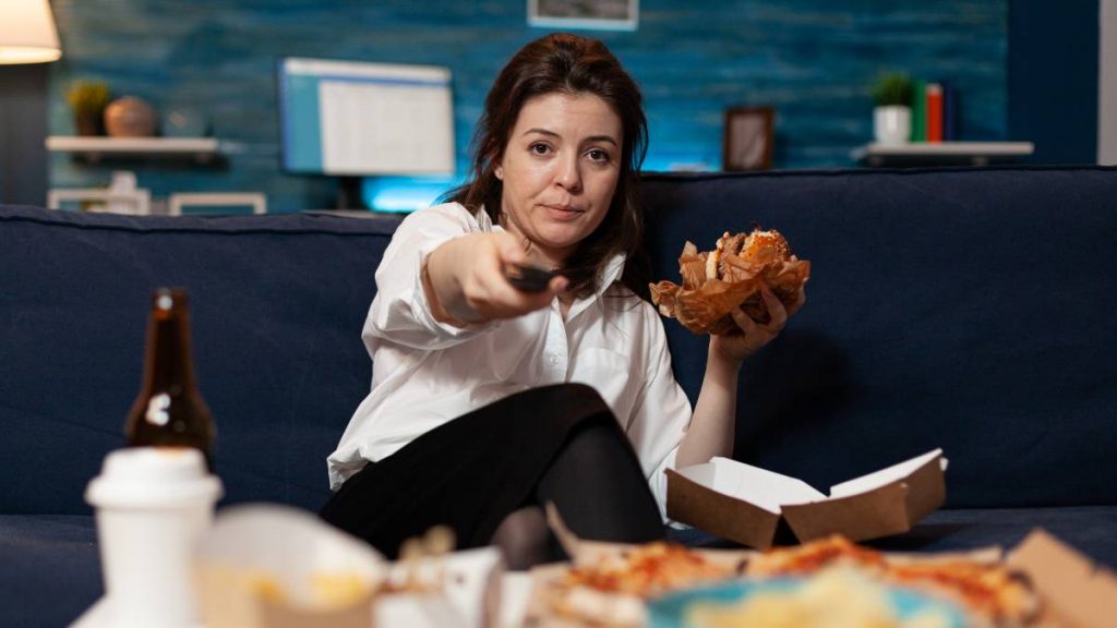 Mujer ve la tele y come hamburguesa el 22 de noviembre